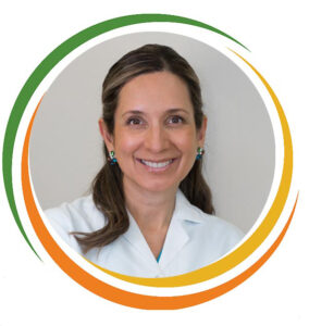 Dentist Headshot - Smiling young lady with brown hair and brown eyes wearing colorful earrings